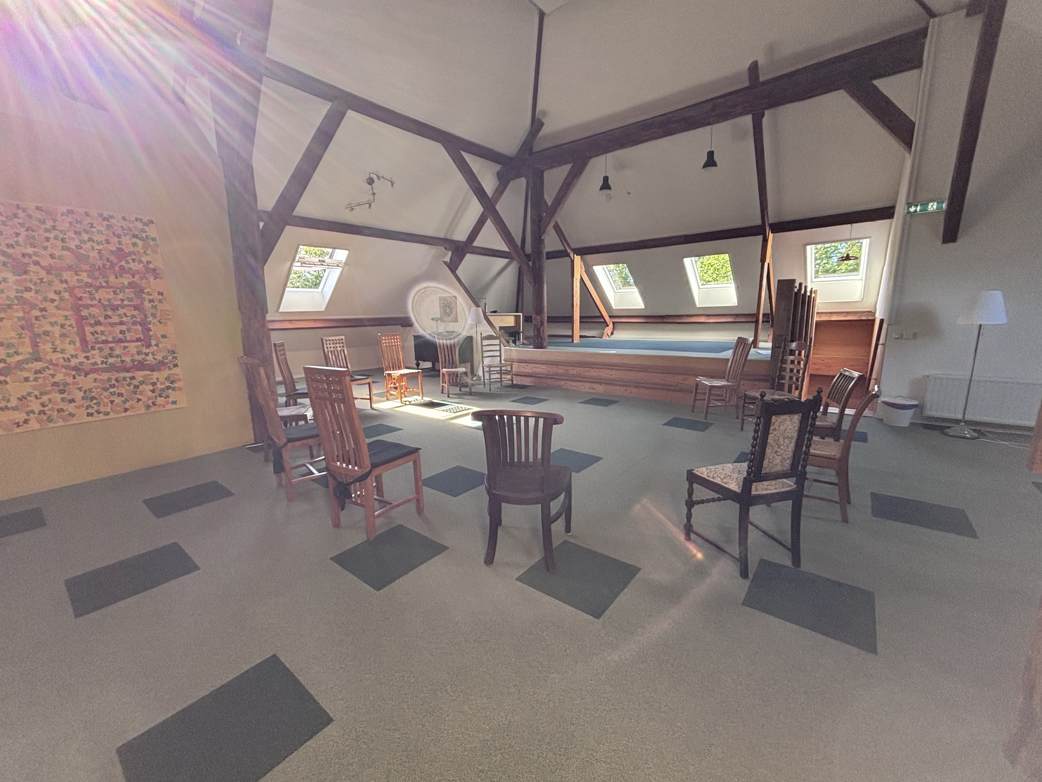 Ruimte met stoelen in een cirkel onder oude balken