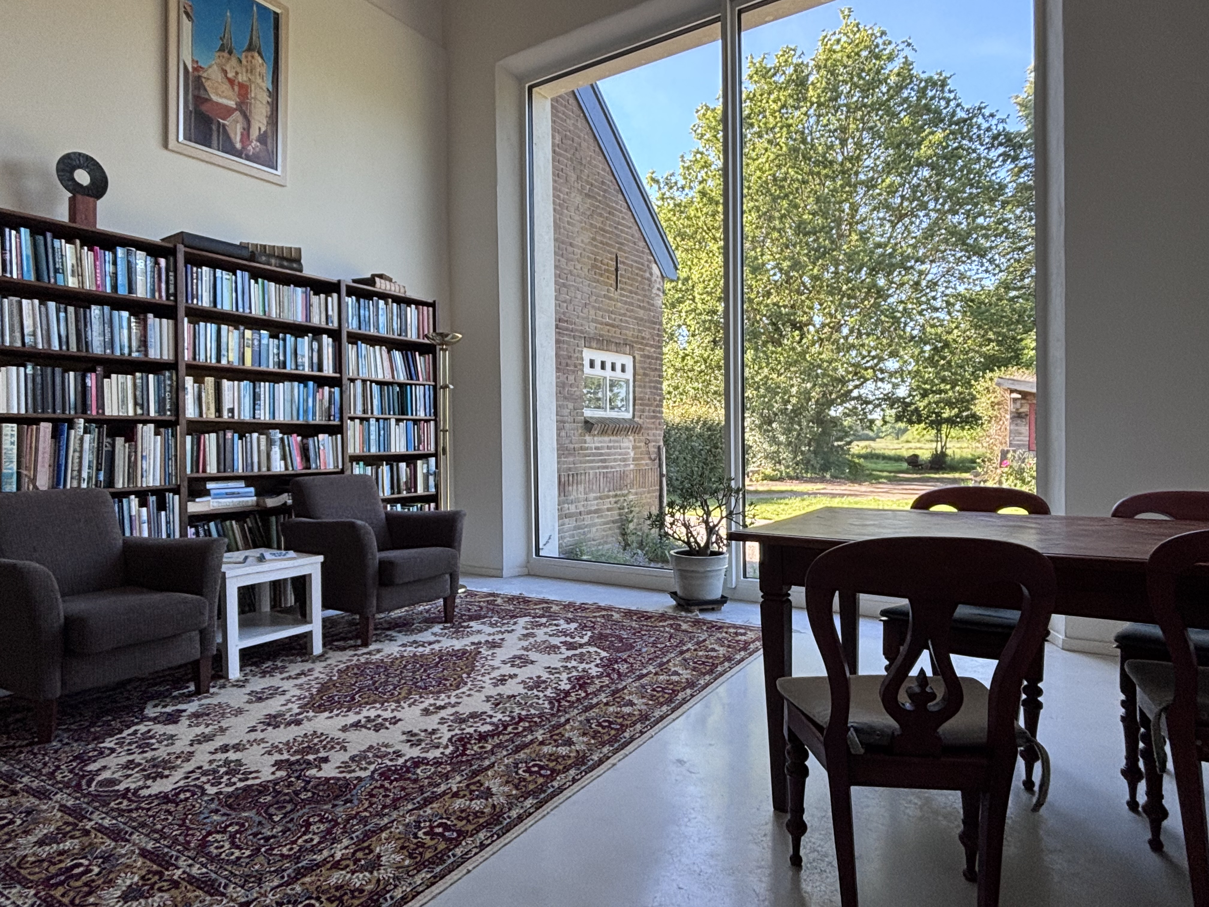 Leeshoek met boekenkast en groot raam met uitzicht
